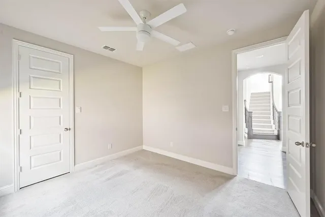 an empty room with a ceiling fan and a window