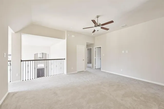 a view of a room with a ceiling fan and window