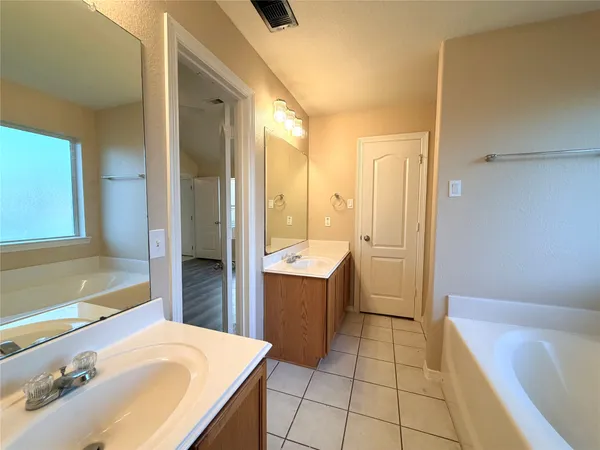 a bathroom with a bathtub sink and mirror
