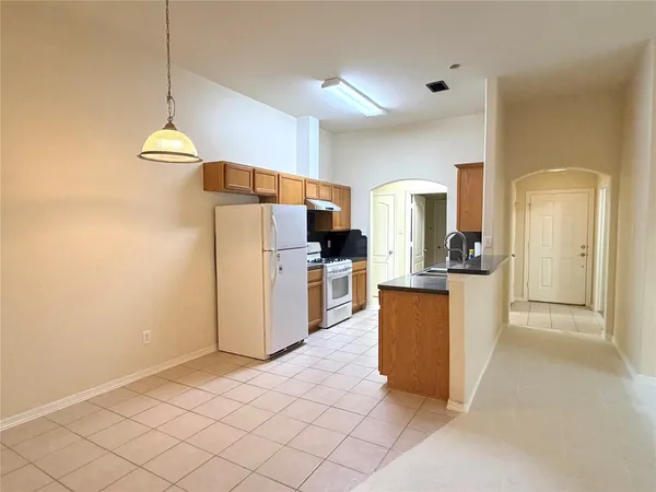 a kitchen with stainless steel appliances granite countertop a refrigerator a stove and a sink with wooden floor