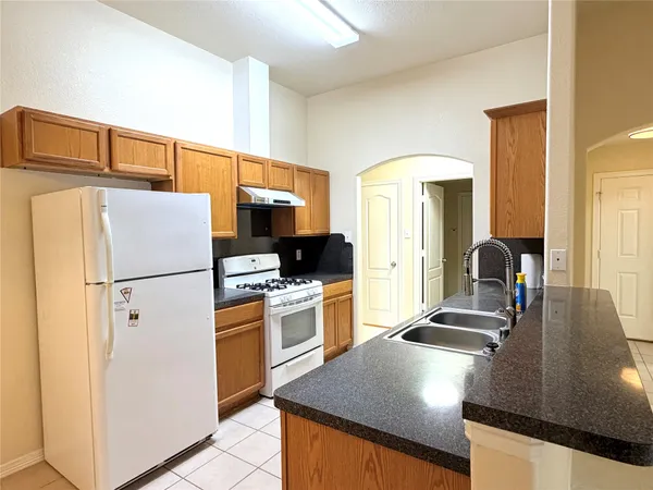 a kitchen with stainless steel appliances a sink a stove and a wooden cabinets
