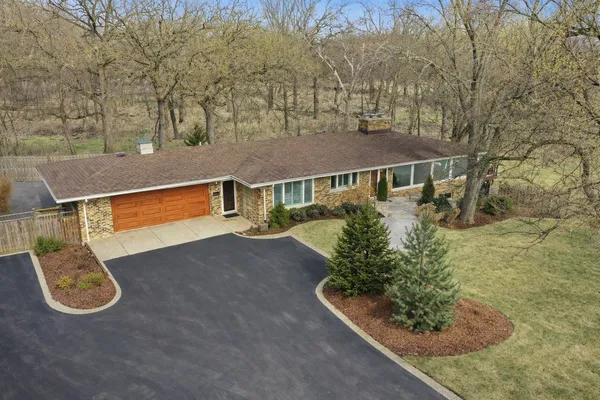 an aerial view of a house with garden space and sitting area