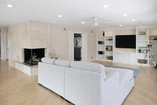 a living room with furniture a flat screen tv and a fireplace