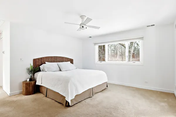 a bedroom with a bed lamp and a window