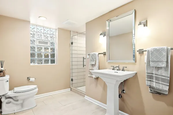 a bathroom with a sink a toilet and a mirror