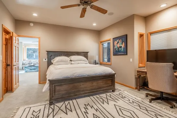 a bedroom with a large bed a flat tv screen and a dresser