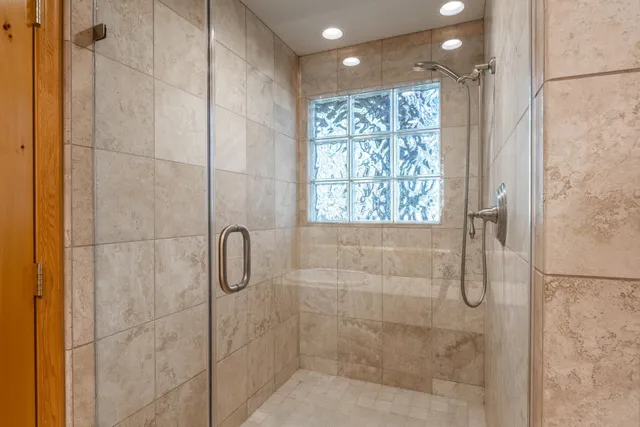 a bathroom with a large tub sink and large window
