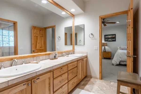 a bathroom with a double vanity sink mirror and bathtub
