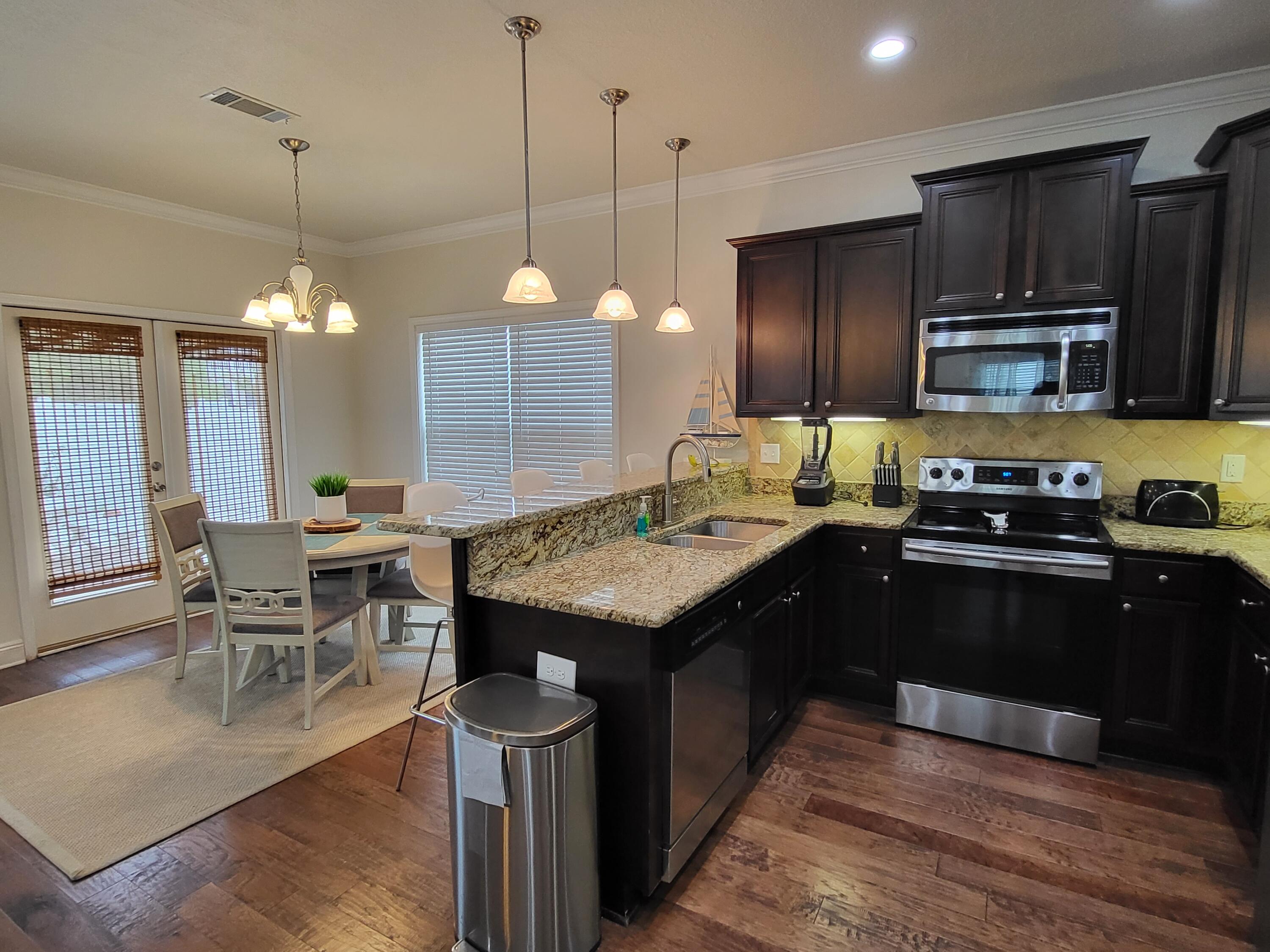 27 Topside Drive Inlet Beach, FL 32461 - Photo 12 of 33 a kitchen with kitchen island granite countertop wooden cabinets and stainless steel appliances