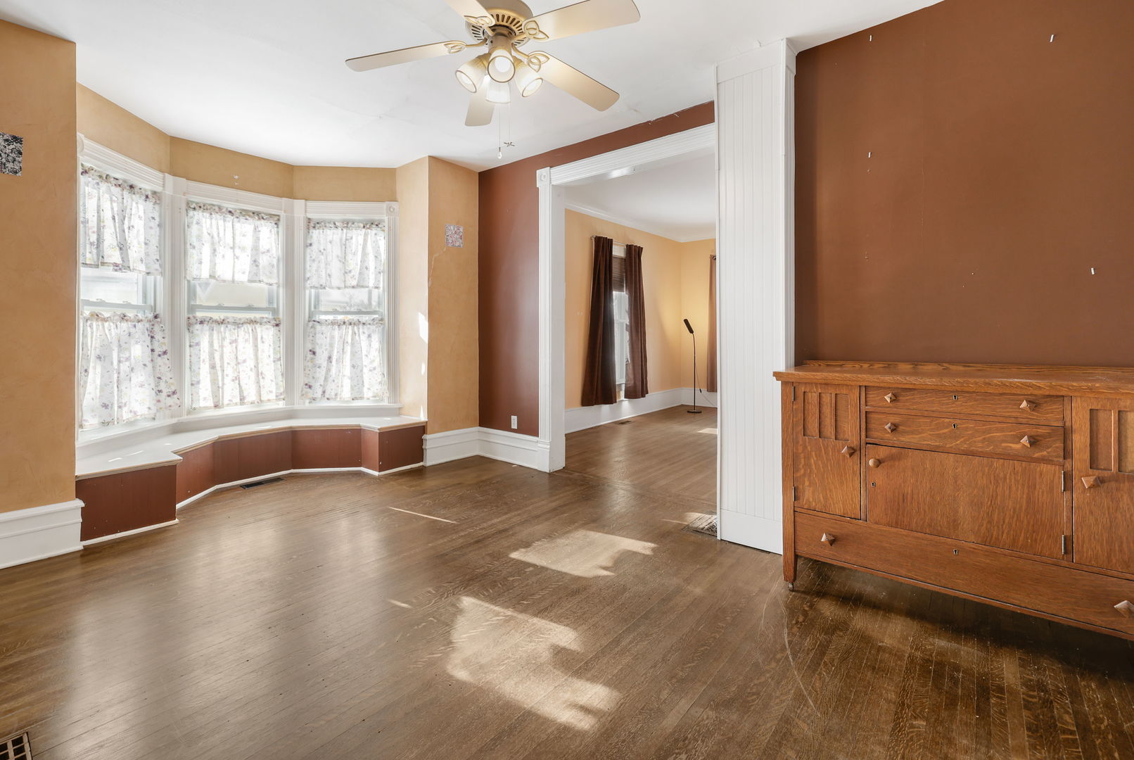 217 Henry Street Elgin, IL 60120 - Photo 4 of 17 a view of an empty room with a window and wooden floor