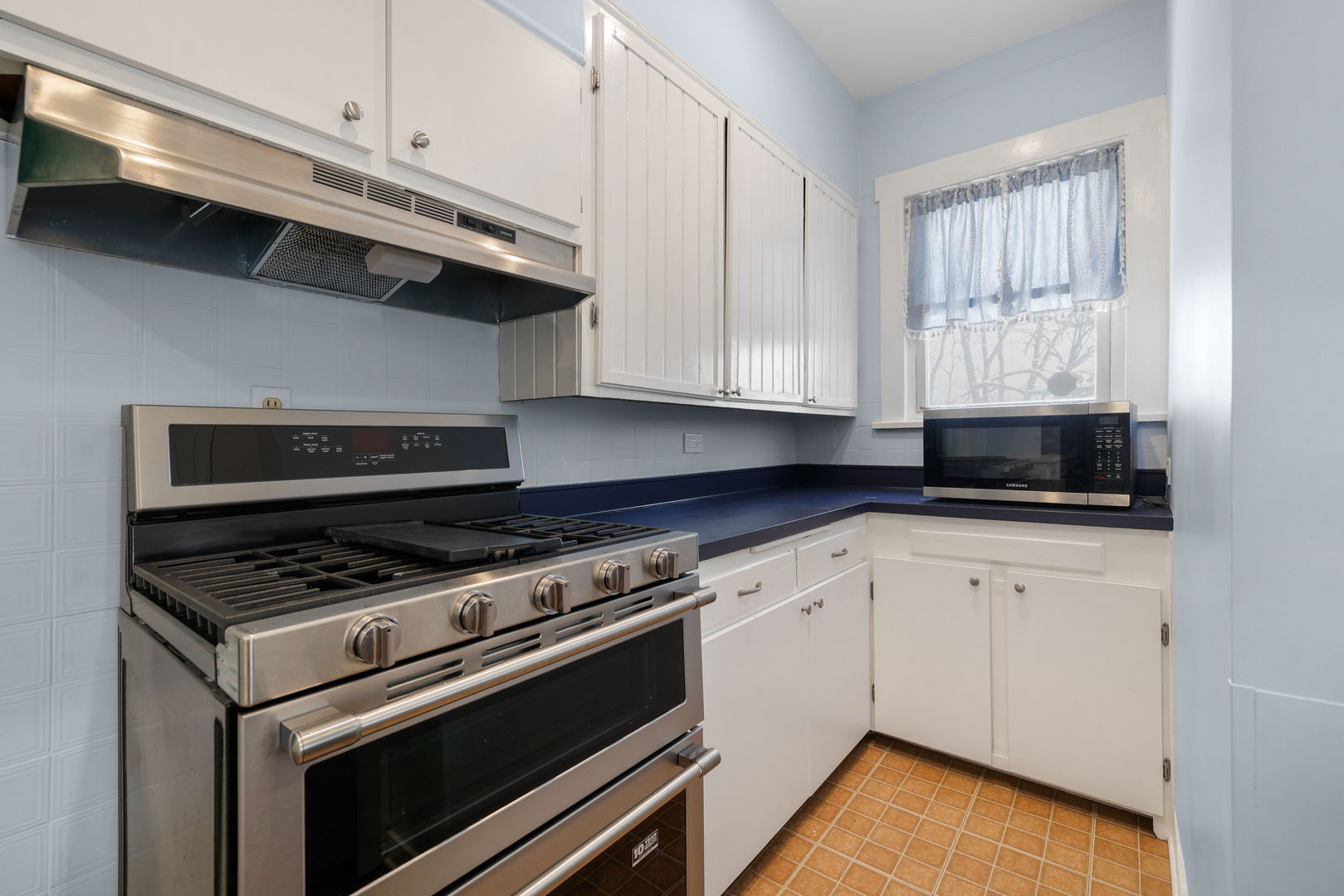 217 Henry Street Elgin, IL 60120 - Photo 7 of 17 a kitchen with stainless steel appliances granite countertop a sink a stove and a microwave