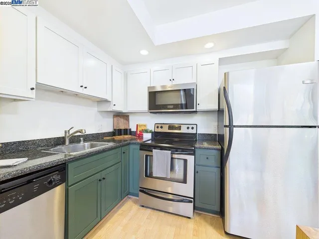 a kitchen with stainless steel appliances granite countertop a stove a sink and a refrigerator