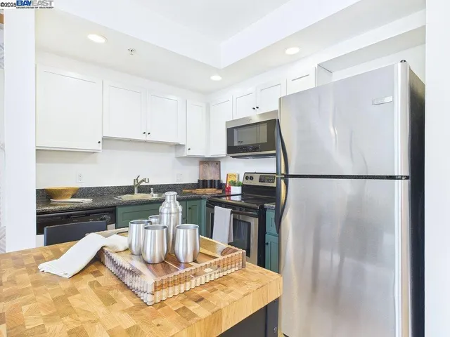 a kitchen with kitchen island a counter top space cabinets and stainless steel appliances