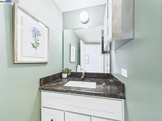 a bathroom with a granite countertop sink and a mirror