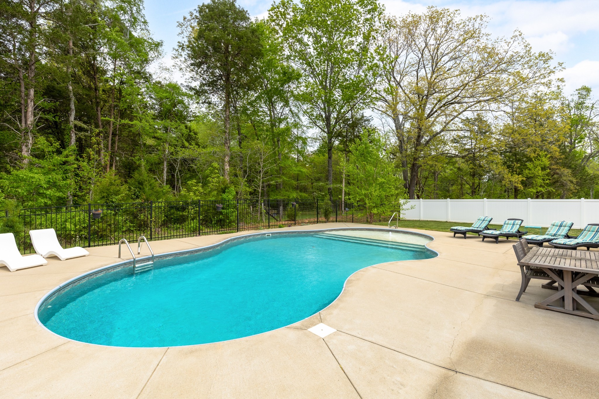 7970 Richpine Drive Murfreesboro, TN 37128 - Photo 28 of 30 a view of a swimming pool with lawn chairs under an umbrella