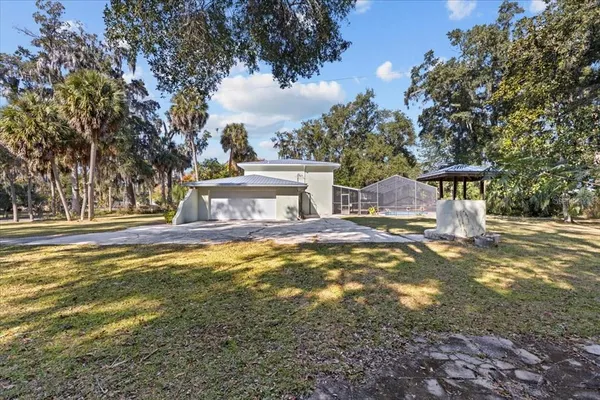 a view of a kitchen with a stove a ceiling fan and wooden floor