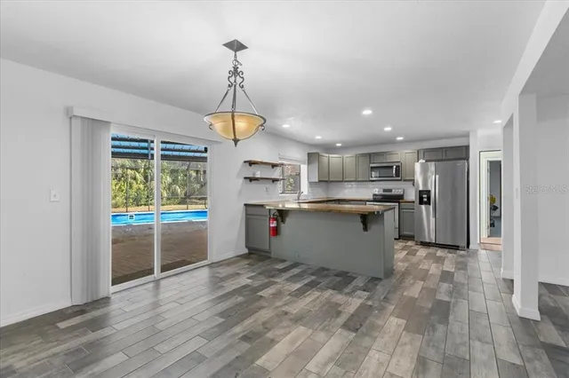 a kitchen with stainless steel appliances granite countertop a sink and dishwasher a stove top oven with wooden floor