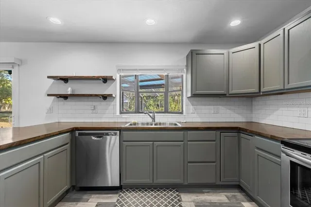 an empty room with ceiling fan and windows