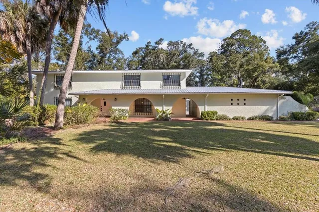 a view of a yard in front of a house with large tree