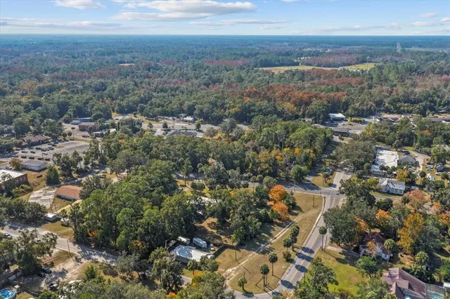 a view of an house with backyard and trees