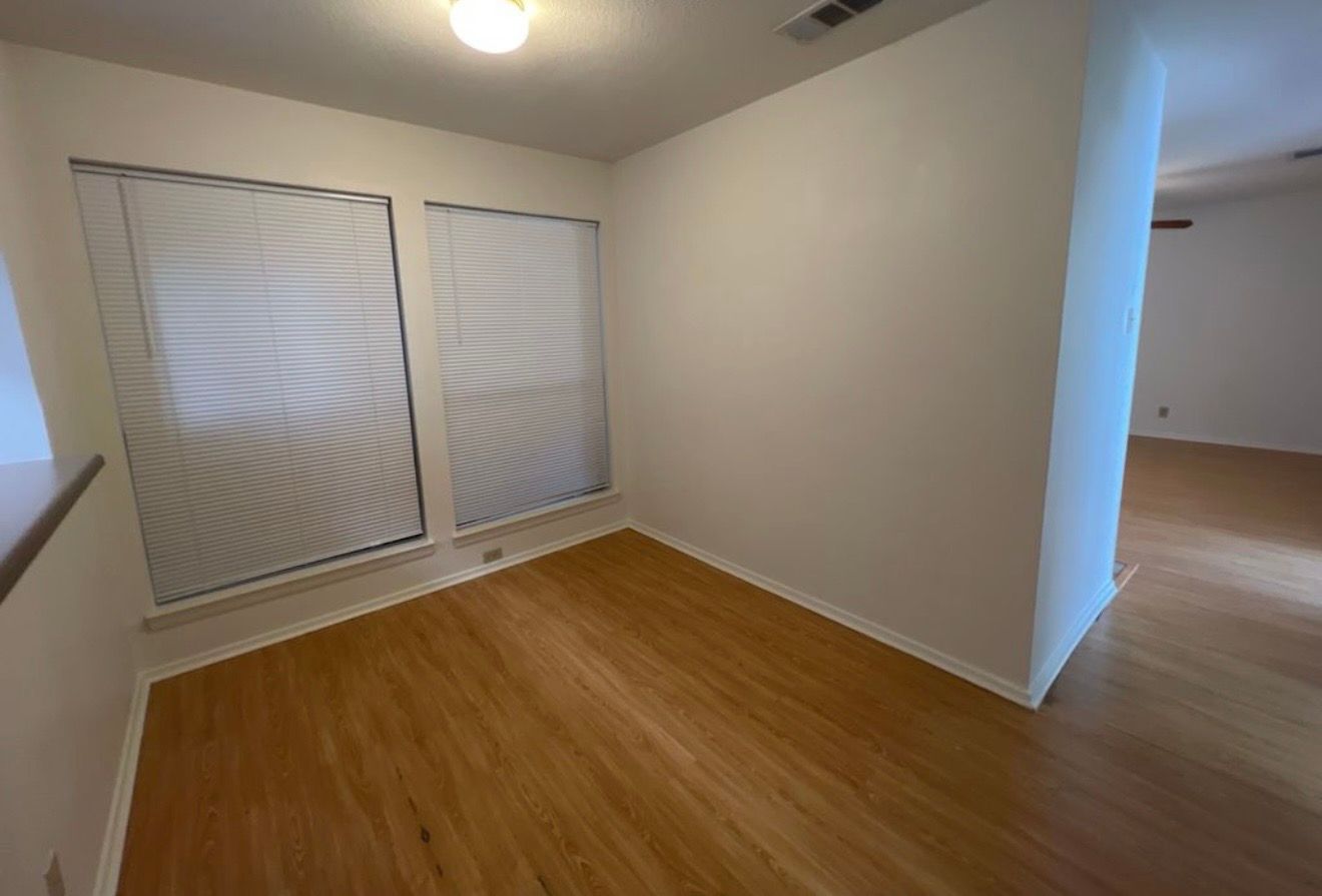 3115 Helms Street, Unit 111 Austin, TX 78705 - Photo 10 of 13 Natural light illuminates this versatile room with durable laminate flooring and crisp white walls.