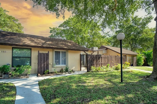 a view of a house with backyard and a tree