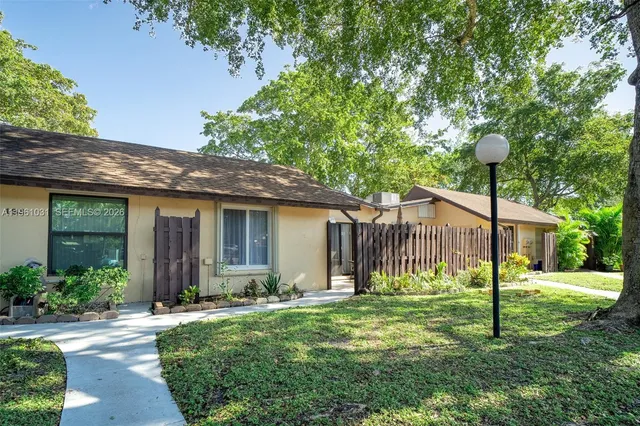 a view of a house with backyard and a tree