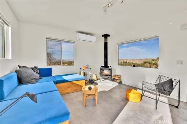 a living room with furniture kitchen view and a large window