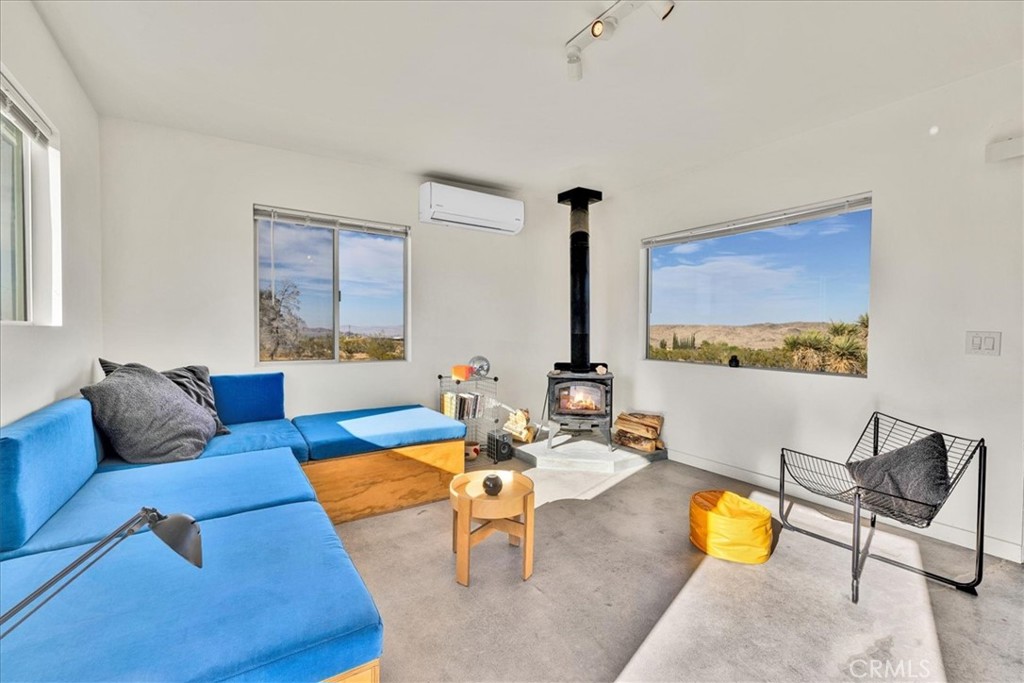 a living room with furniture kitchen view and a large window