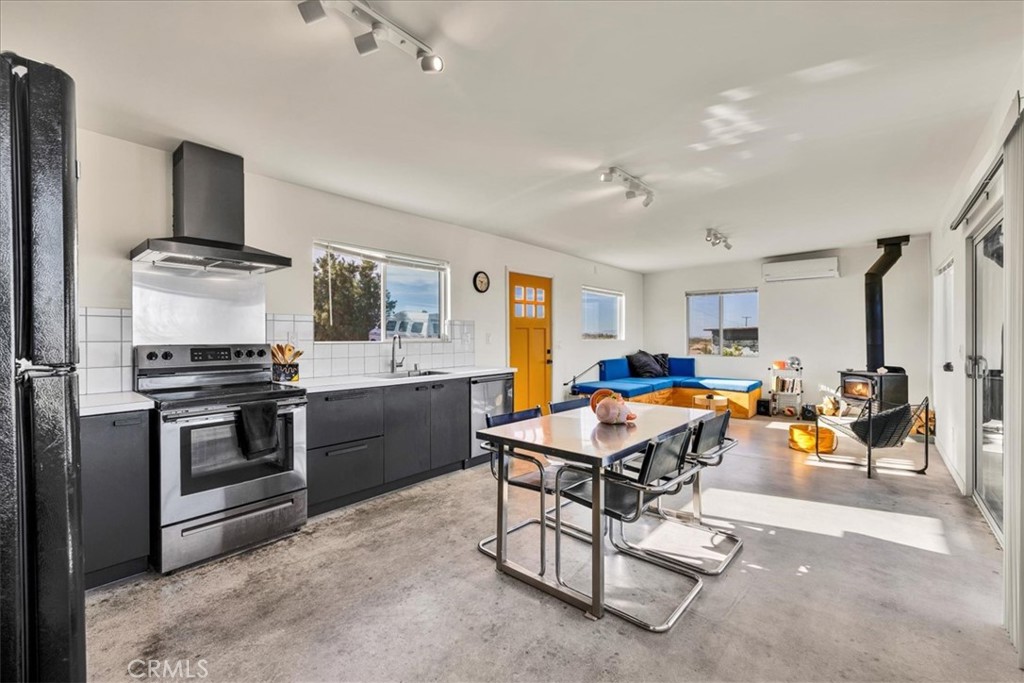 2625 Geronimo Trail Yucca Valley, CA 92285 - Photo 12 of 57 a view of a kitchen with kitchen island stainless steel appliances a stove a sink a counter top space and living room view