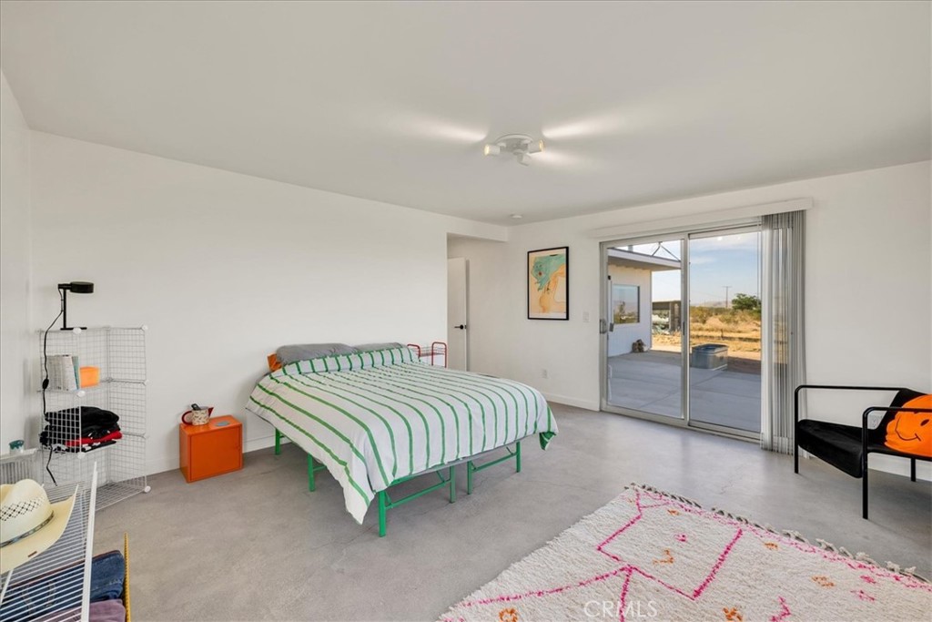 2625 Geronimo Trail Yucca Valley, CA 92285 - Photo 16 of 57 a spacious bedroom with a bed a table and a dresser