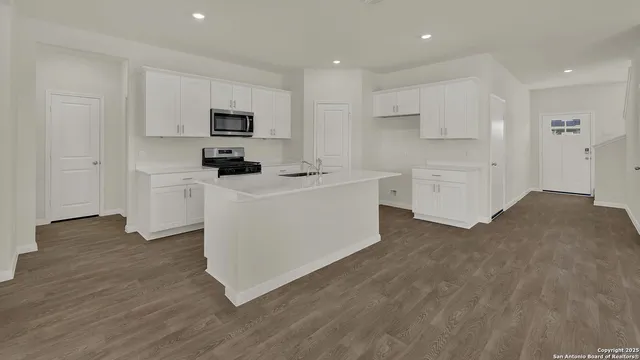 a kitchen with white cabinets and stainless steel appliances