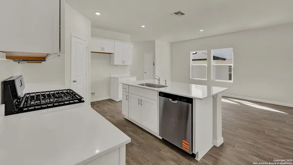 a kitchen with granite countertop a sink and a refrigerator