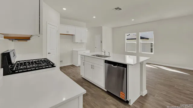 a kitchen with granite countertop a sink and a refrigerator