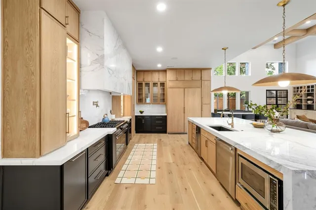 a large kitchen with kitchen island a large counter space a sink appliances and cabinets