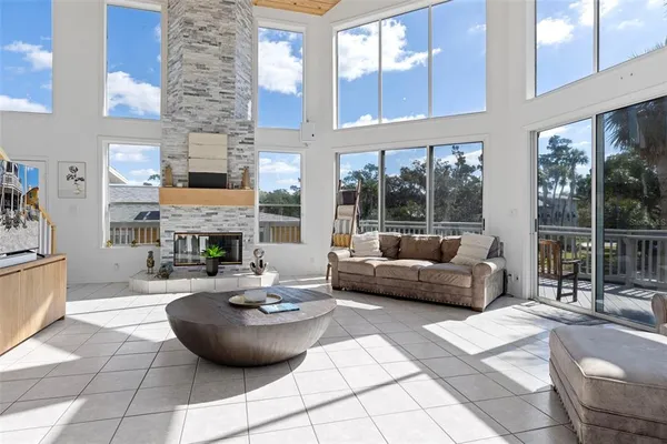 a living room with furniture a fireplace and a floor to ceiling window