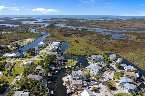 an aerial view of ocean and residential houses with outdoor space
