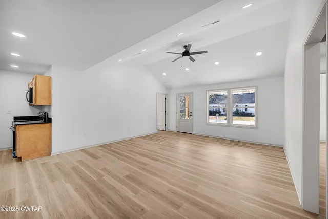 a view of empty room with wooden floor and window