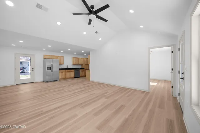 a view of empty room with wooden floor and window
