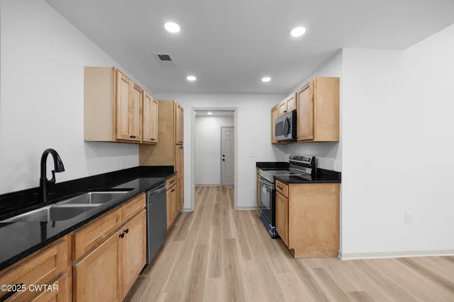 a kitchen with stainless steel appliances granite countertop a sink stove and refrigerator
