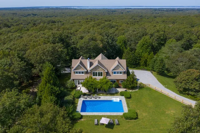 an aerial view of residential houses with outdoor space and trees