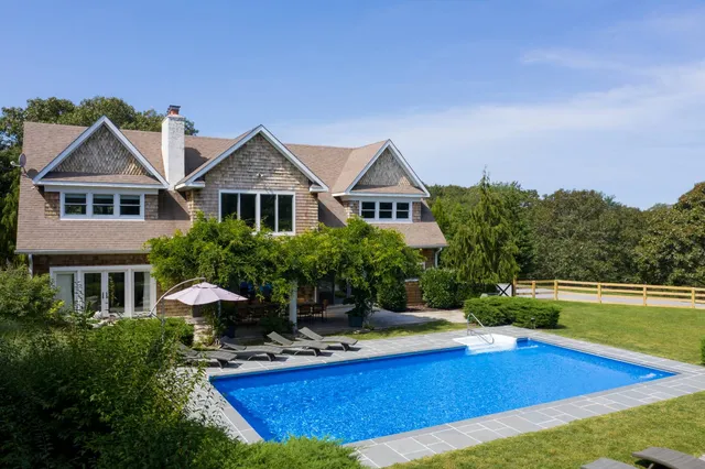 a view of a house with a swimming pool and a chairs