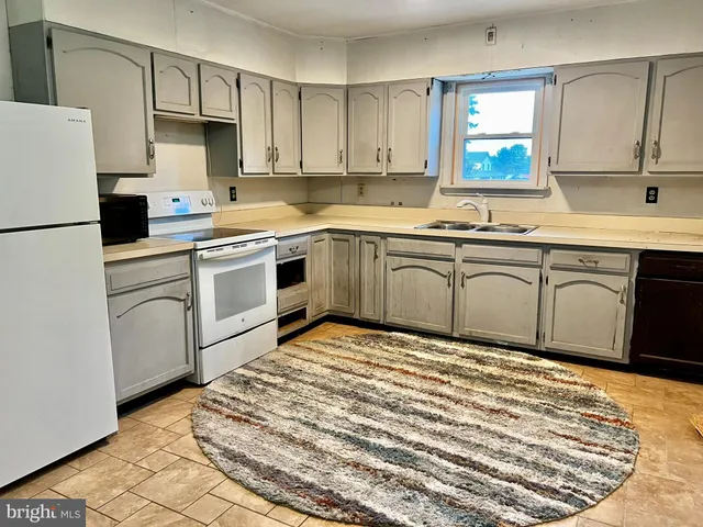 a view of an empty room with wooden floor and door