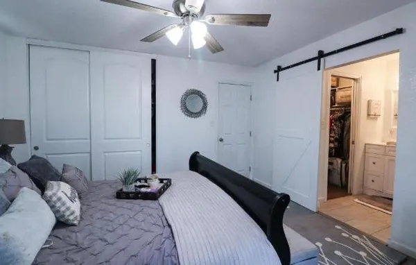 a bedroom with a bed and a chandelier fan
