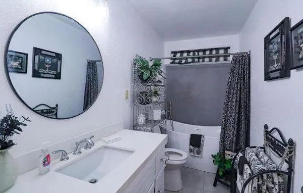 a bathroom with a sink mirror and toilet