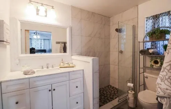 a bathroom with a sink a toilet and shower