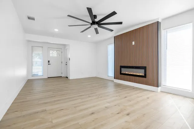 a view of an empty room with a ceiling fan and window