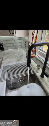 a kitchen with stainless steel appliances a stove and a flat screen tv