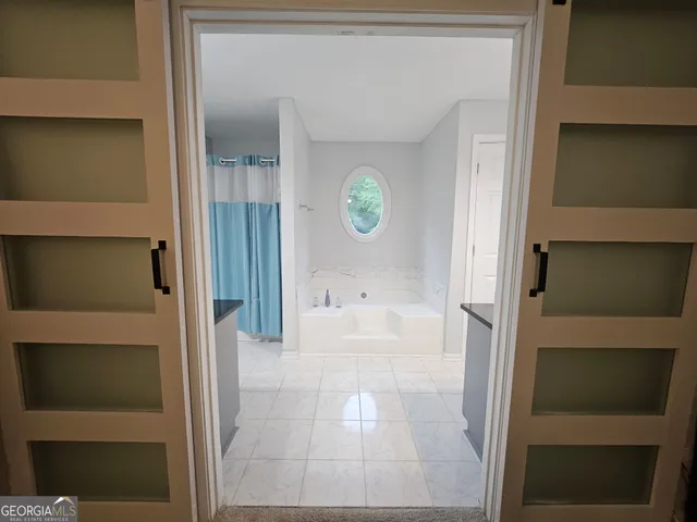 a living room with furniture a flat screen tv and a floor to ceiling window