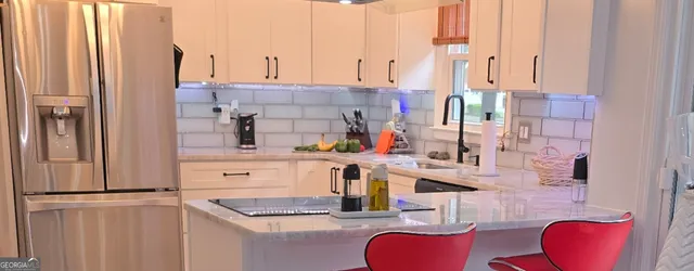 a bedroom with a bed and a refrigerator